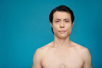 Studio portrait of shirtless fit young man looking at camera