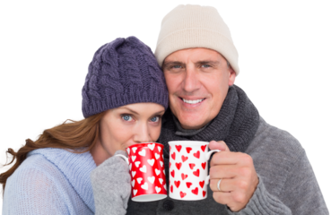 Happy couple in warm clothing holding mugs