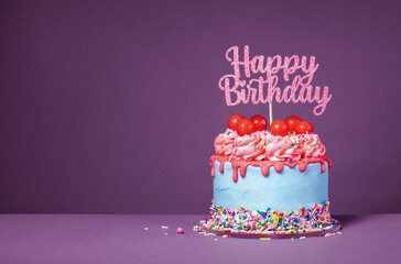 Fun happy birthday drip cake over a purple background - obrazy, fototapety, plakaty
