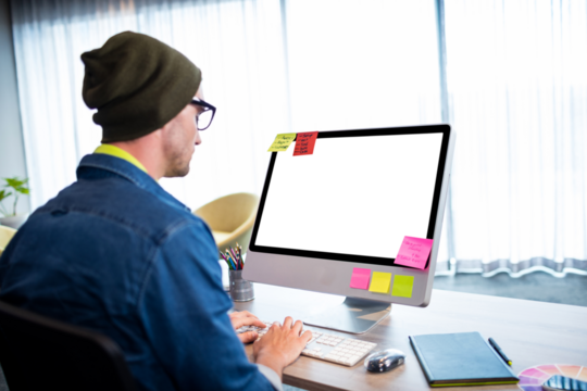 Rear view of man working on computer