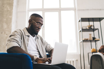 Black man working on laptop sitting in modern office