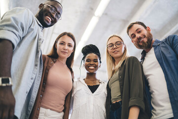 Group of diverse friends standing together in room