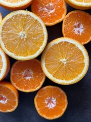 oranges and tangerines, slices on a dark background, close up