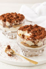 Homemade traditional Italian dessert, classic Tiramisu without eggs and heavy cream, on white background.