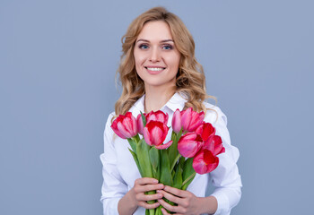 glad girl with spring tulip flowers on grey background