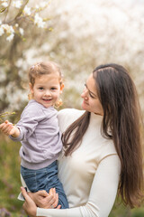 Fototapeta premium Young mother and her cute daughter having a fun in spring time park Petrin in Prague, Europe