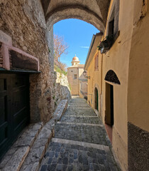 Fototapeta na wymiar A narrow street among the old houses of Torre Cajetani, a medieval town in the province of Frosinone in Italy.