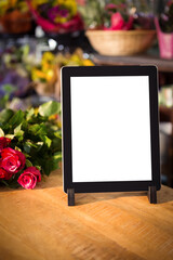 Digital tablet with flowers on table