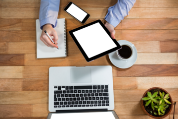 Cropped image of human hand using digital tablet while writing in personal organizer