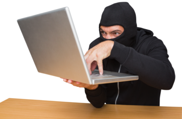 Hacker using laptop to steal identity at desk
