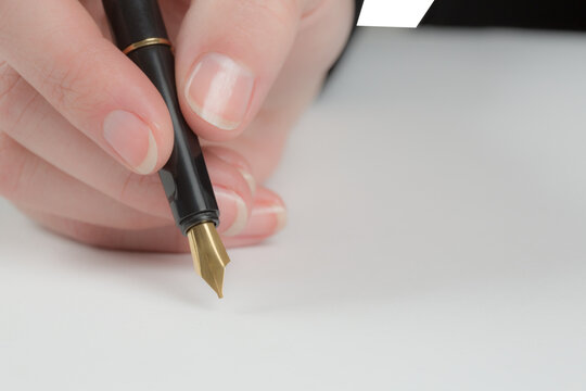 Businesswomans hand writing with fountain pen