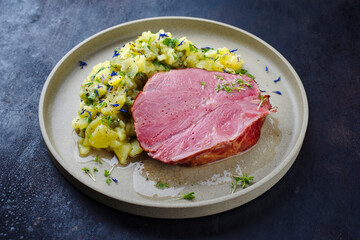 Traditionell geschmorte badisches Schäufele Scheibe serviert mit Kartoffelsalat als Draufsicht auf...