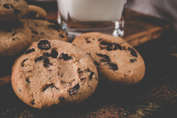 fresh healthy milk and cookies on dark wood background