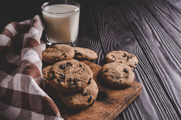 fresh healthy milk and cookies on dark wood background