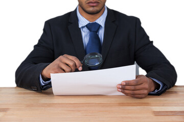 Businessman looking at document through magnifying glass