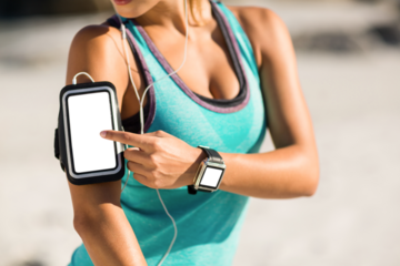 Midsection of woman using smartphone on armband