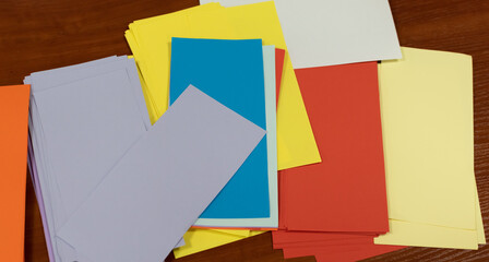Multi-colored paper cards for notes close-up laid out on office table. Top view