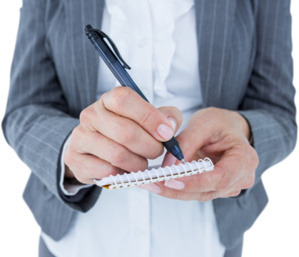 Midsection of businesswoman writing on notepad
