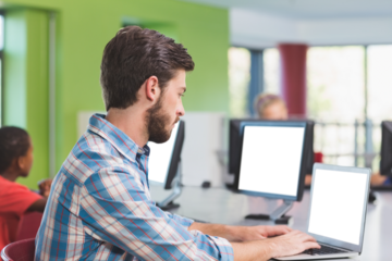 Teacher using laptop in classroom