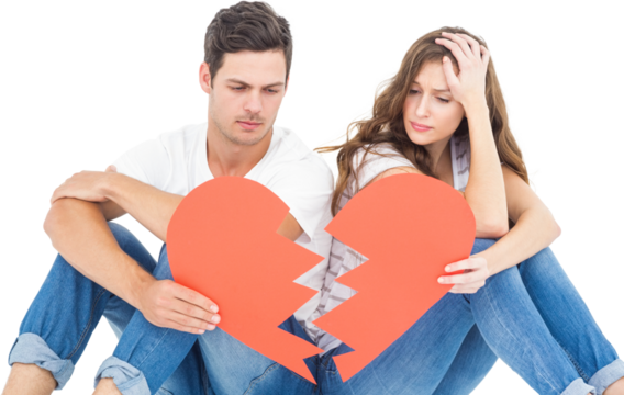 Young couple sitting on floor with broken heart shape paper