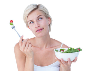 Thoughtful blonde eating salad 