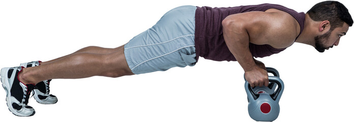 Muscular man doing push ups with kettlebells