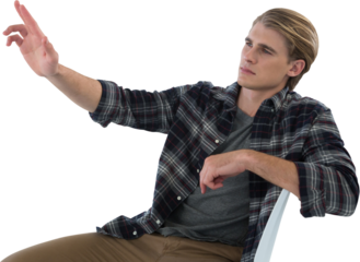 Businessman touching imaginary interface while sitting on chair