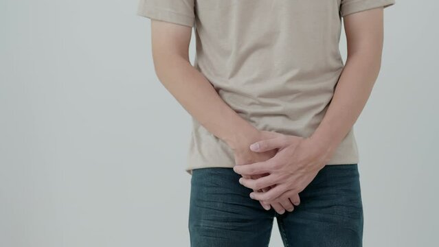 Man hold hand in front of private parts feeling discomfort from disease and inflammation. Venereal, testicular cancer. bladder problems, erectile dysfunction, premature ejaculation, prostate cancer