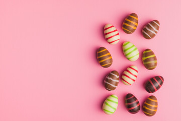 Chocolate easter eggs on pink background. Top view.