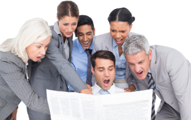 Surprising business people looking at newspaper 