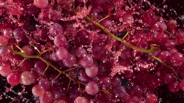 Super Slow Motion Shot of Fresh Grape Falling into Red Wine on Black Background at 1000 fps.