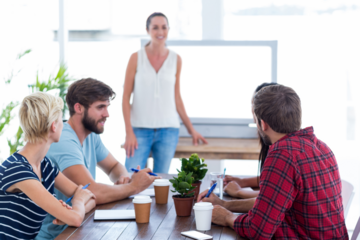 Casual businesswoman giving presentation to her colleagues
