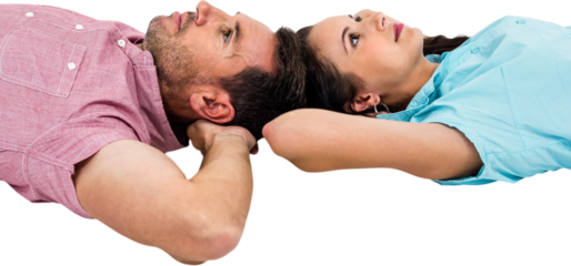Couple relaxing on floor with hands on their heads