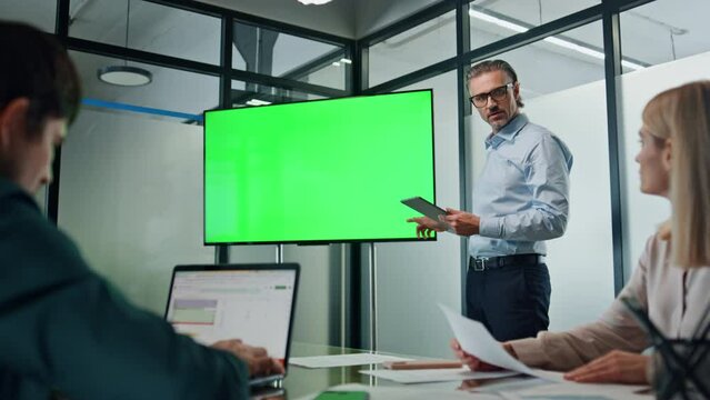 Businessman making chromakey presentation office. Coach pointing at green screen