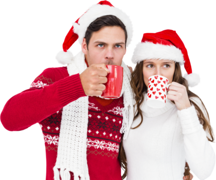 Couple with santa hats drinking hot beverage