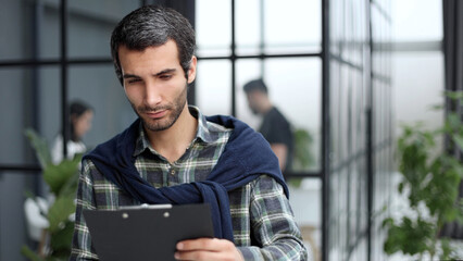 Low angle view of businessman looking at paper folder in office