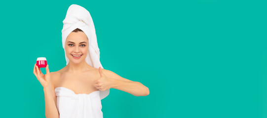 Obraz premium happy woman in towel with skin cream on blue background. thumb up. Beautiful woman isolated face portrait, banner with mock up copy space.