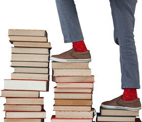 Low section of boy climbing stack of books