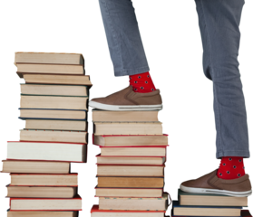 Low section of boy climbing stack of books