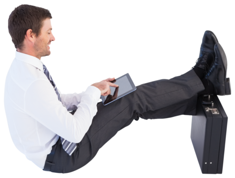Businessman sitting with feet up while using his tablet - Powered by Adobe