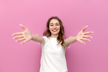 young cute woman in white t-shirt with outstretched arms wants hug, the girl hugs and holds her hands in front of her - obrazy, fototapety, plakaty