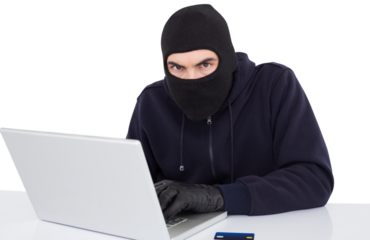 Hacker in balaclava hacking a laptop