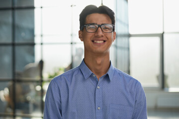 Close-up of smiling asian businessman standing in modern office