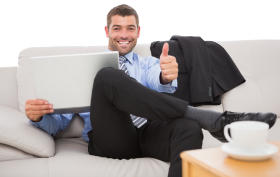 Businessman with laptop gesturing thumbs up on sofa