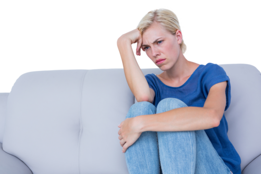 Thoughtful blonde woman sitting on the couch