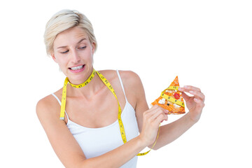 Pretty blonde choosing between eating pizza or not 