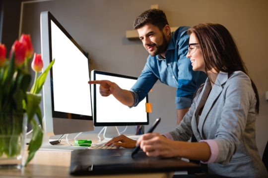 Graphic designer pointing at monitor