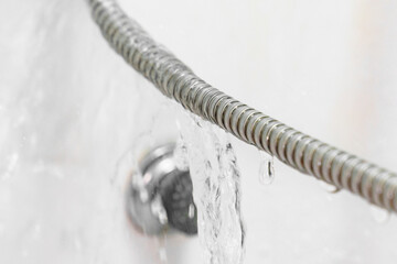water is flowing from a broken shower hose. 