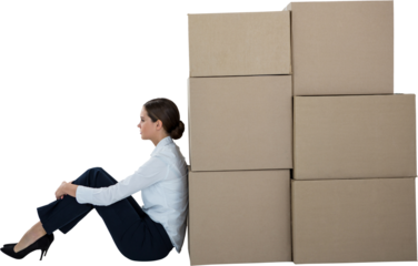 Businesswoman leaning on cardboard boxes against white background
