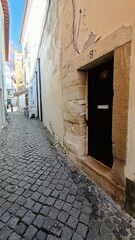 The old alley and the entrance to the house. Antique doorway made of natural stone